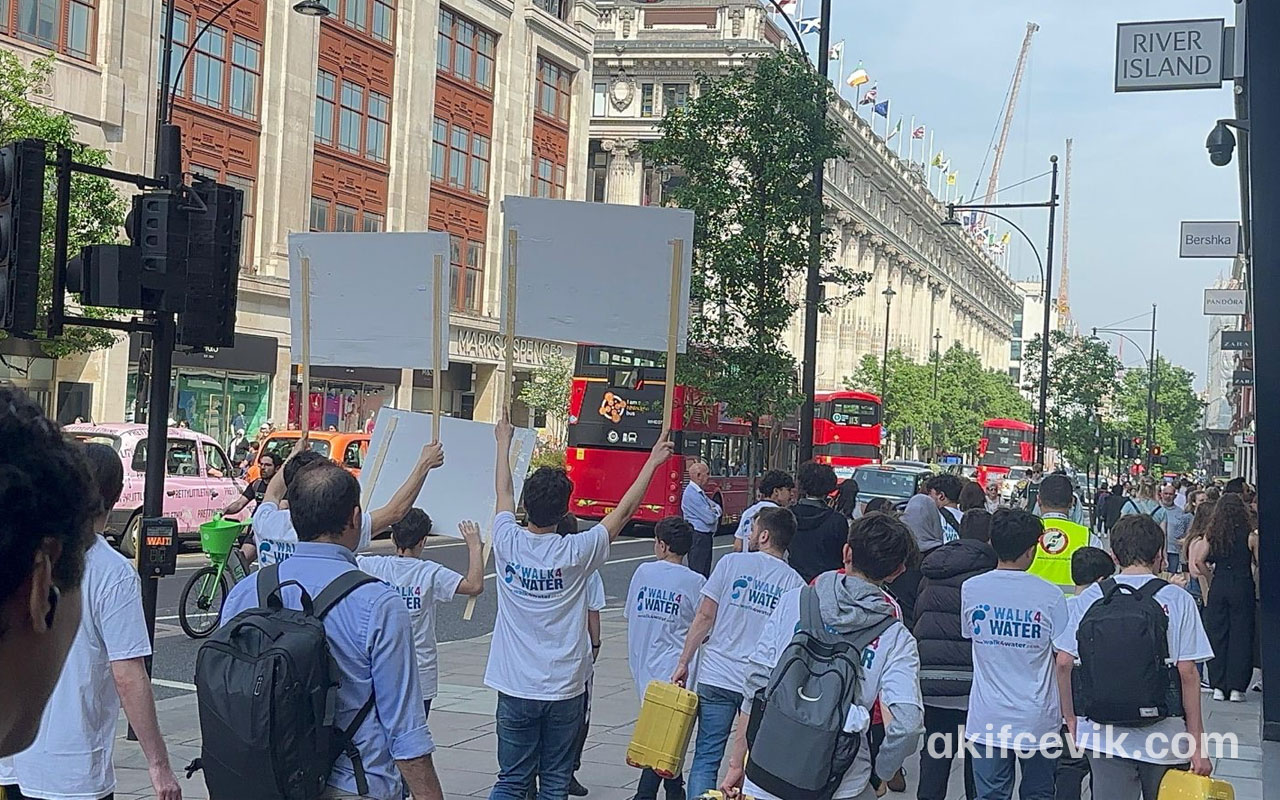 a group walking through london streets carrying water containers