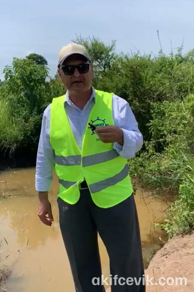 a volunteer inspecting a site beside the water