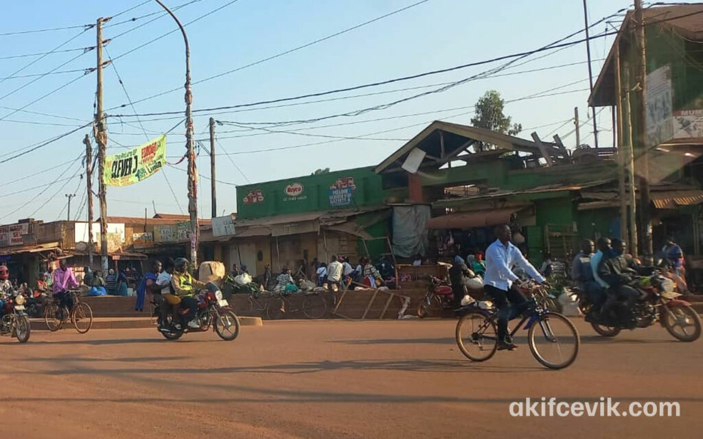 a ugandan street with cyclists passing through