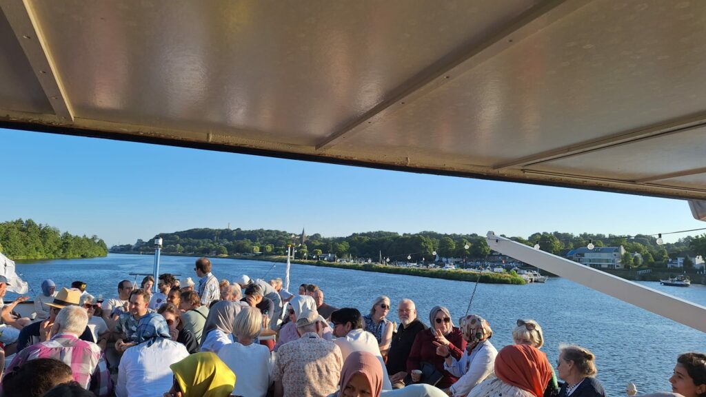 teilnehmende versammelt auf dem deck des bootes auf dem fluss